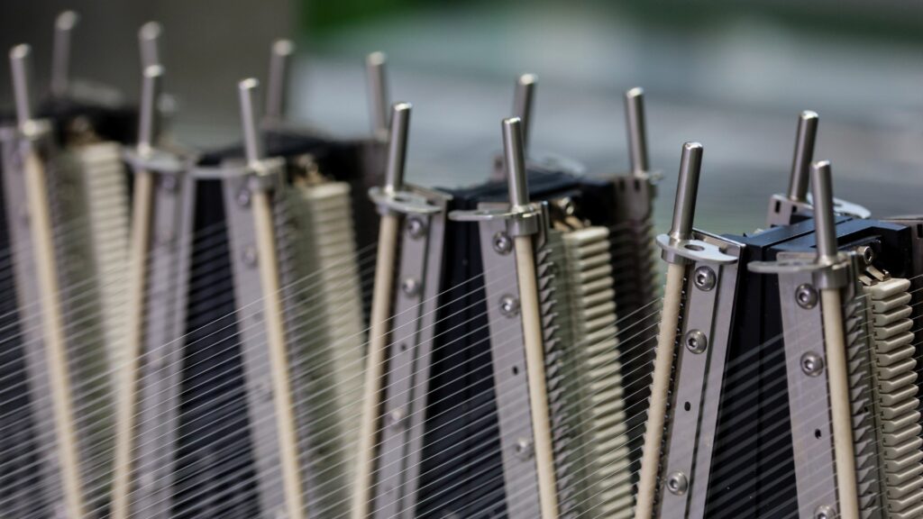 How High-Performance Materials Enable Circularity A close-up view of the ECONYL® regeneration system processing nylon filaments on industrial equipment.
